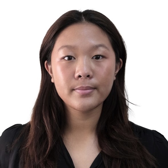Studio headshot of Erin with long dark hair wearing a black top against a white background.