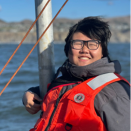 Image of Corey Kwan smiling and wearing a life jacket while on a boat