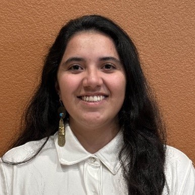 Headshot of Yael Sarai Alonso-Lopez wearing a white button up shirt and smiling